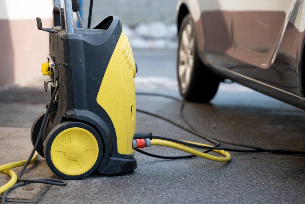 Un Kärcher posé sur le sol près d'une voiture