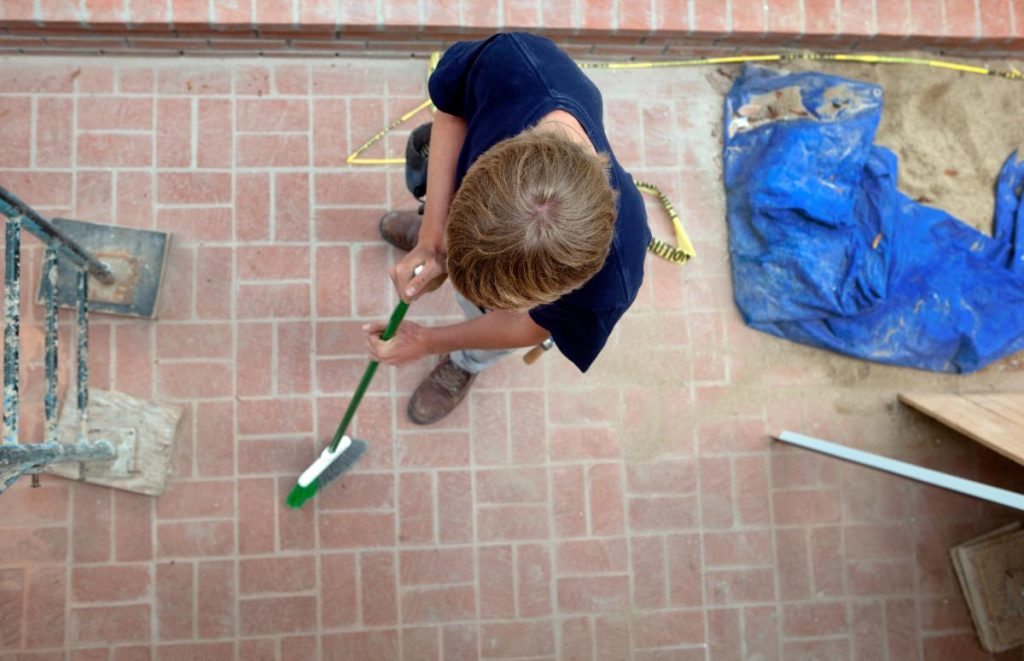 Un homme qui nettoie le tomette avant d'appliquer l'huile de lin