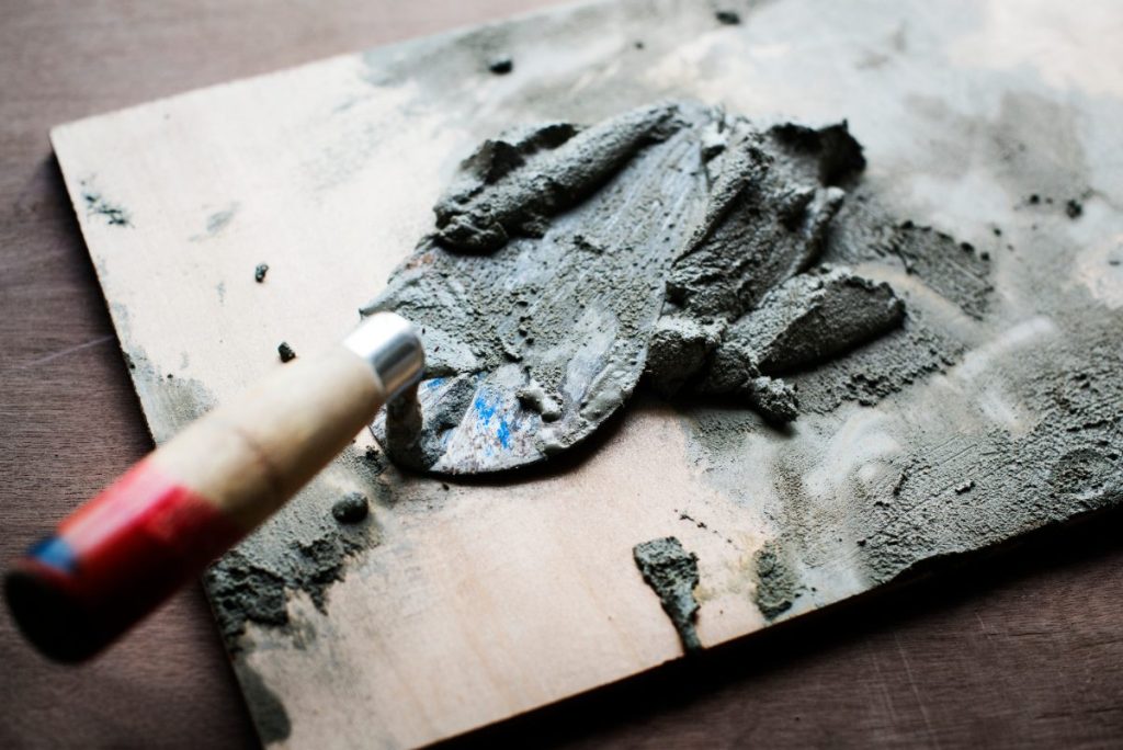 Ciment sur truelle reposant sur une planche
