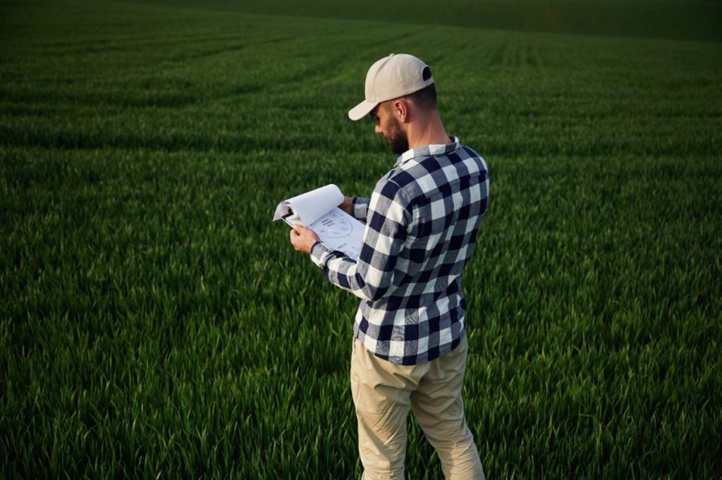 Un homme qui examine un rapport de terrain avec des papiers