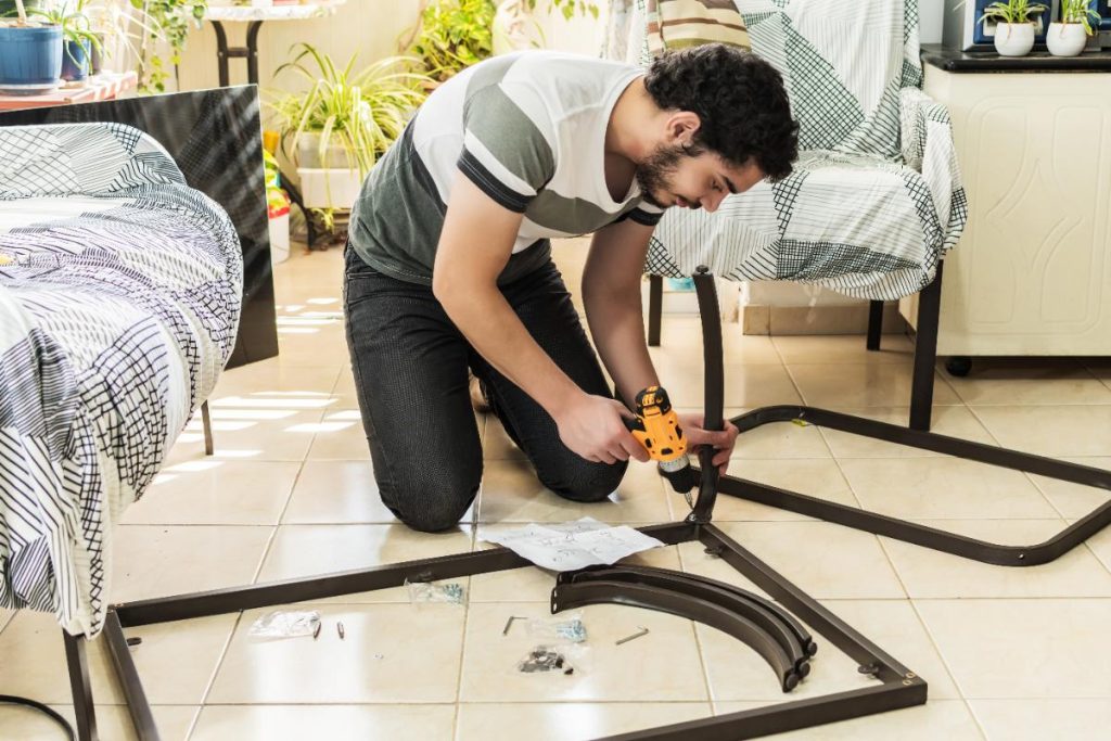 Un homme qui fabrique un arceau de lit dans la chambre