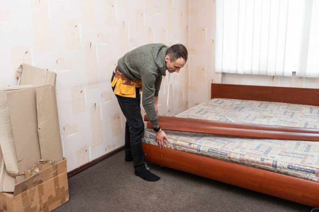 Un homme faisant assembler des meubles pour le lit