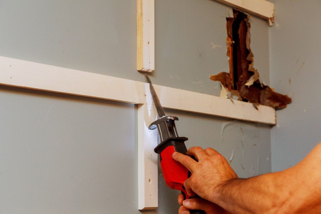 Un homme qui utilise une scie électrique pour couper du placo