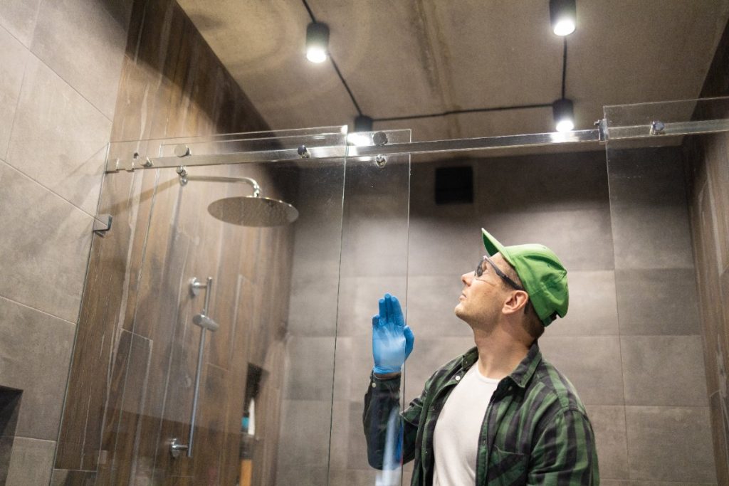 Un ouvrier qui inspecte une porte de douche