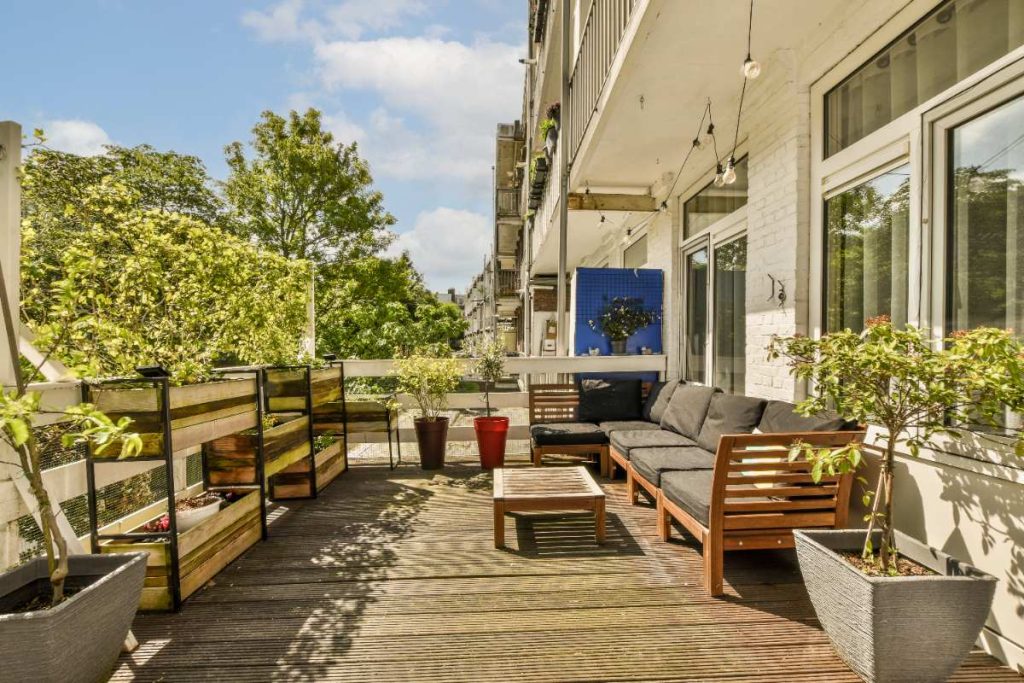 Une terrasse en bois avec des plantes vertes autour