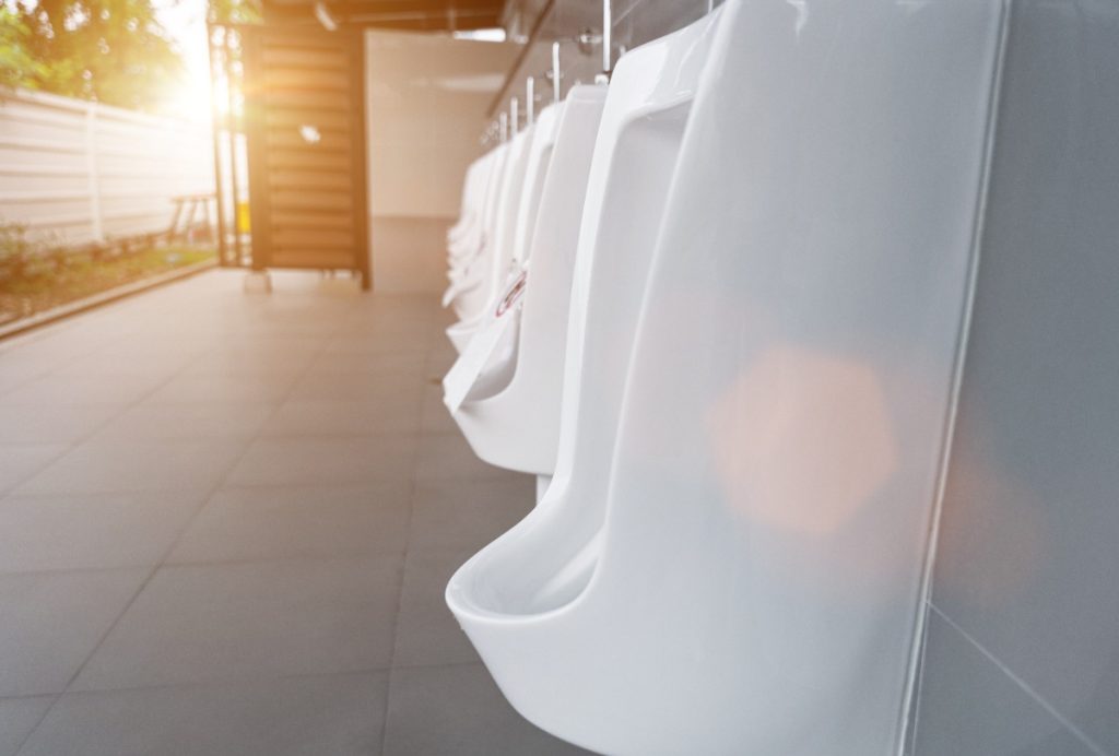Une rangée d'urinoirs blancs dans des toilettes