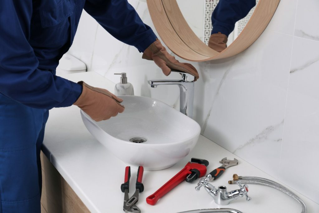 Un plombier réparant un lavabo de salle de bain