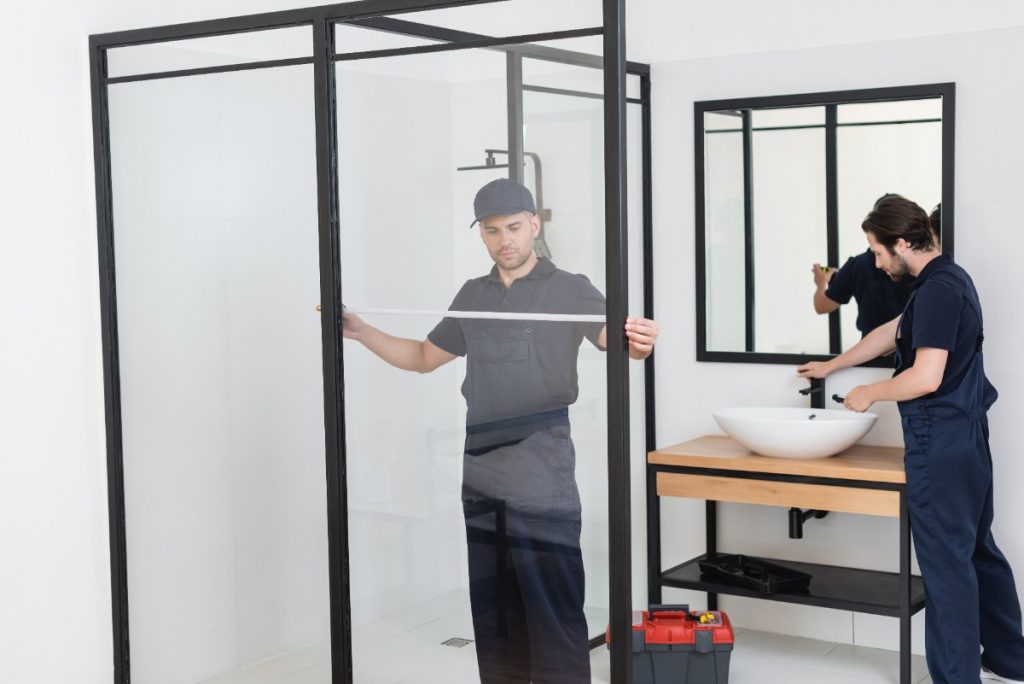 Des travailleurs installant une douche moderne