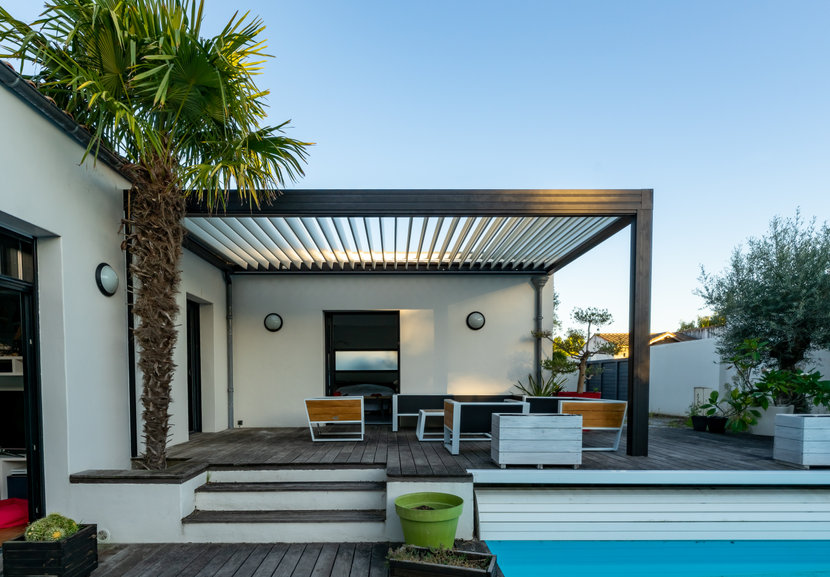Pergola bioclimatique confortable dans un jardin